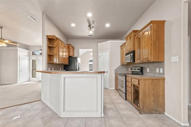 a kitchen with a sink refrigerator and cabinets