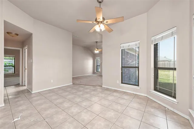 a view of an empty room with a fireplace and a window