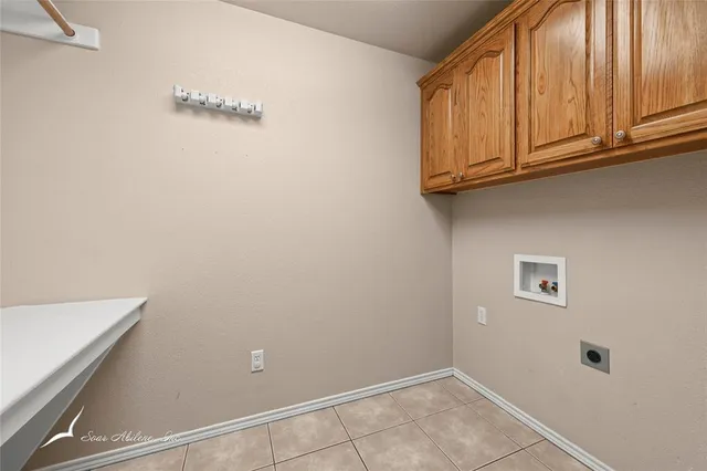 an empty room with windows fireplace and fan