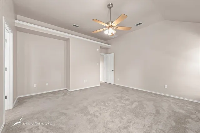 a view of an empty room with a chandelier fan