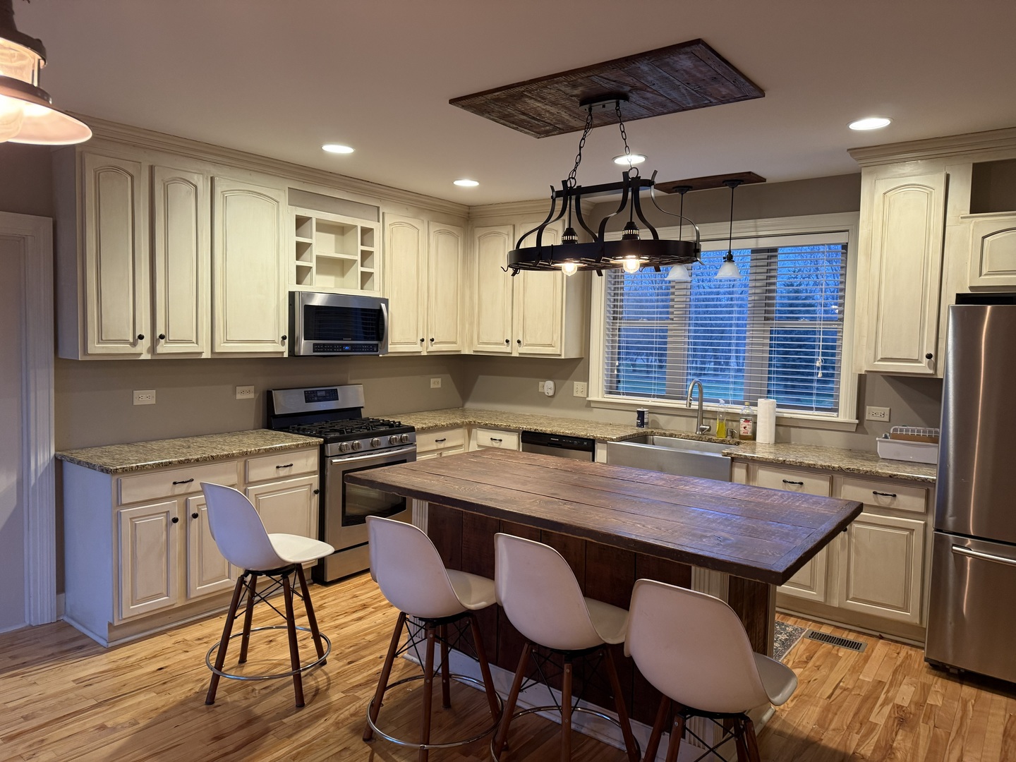 42W546 Highway 64 St. Charles, IL 60175 - Photo 8 of 18 a kitchen with stainless steel appliances granite countertop a stove a sink dishwasher a dining table and chairs with wooden floor
