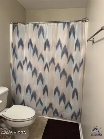 a white toilet sitting next to a shower curtain