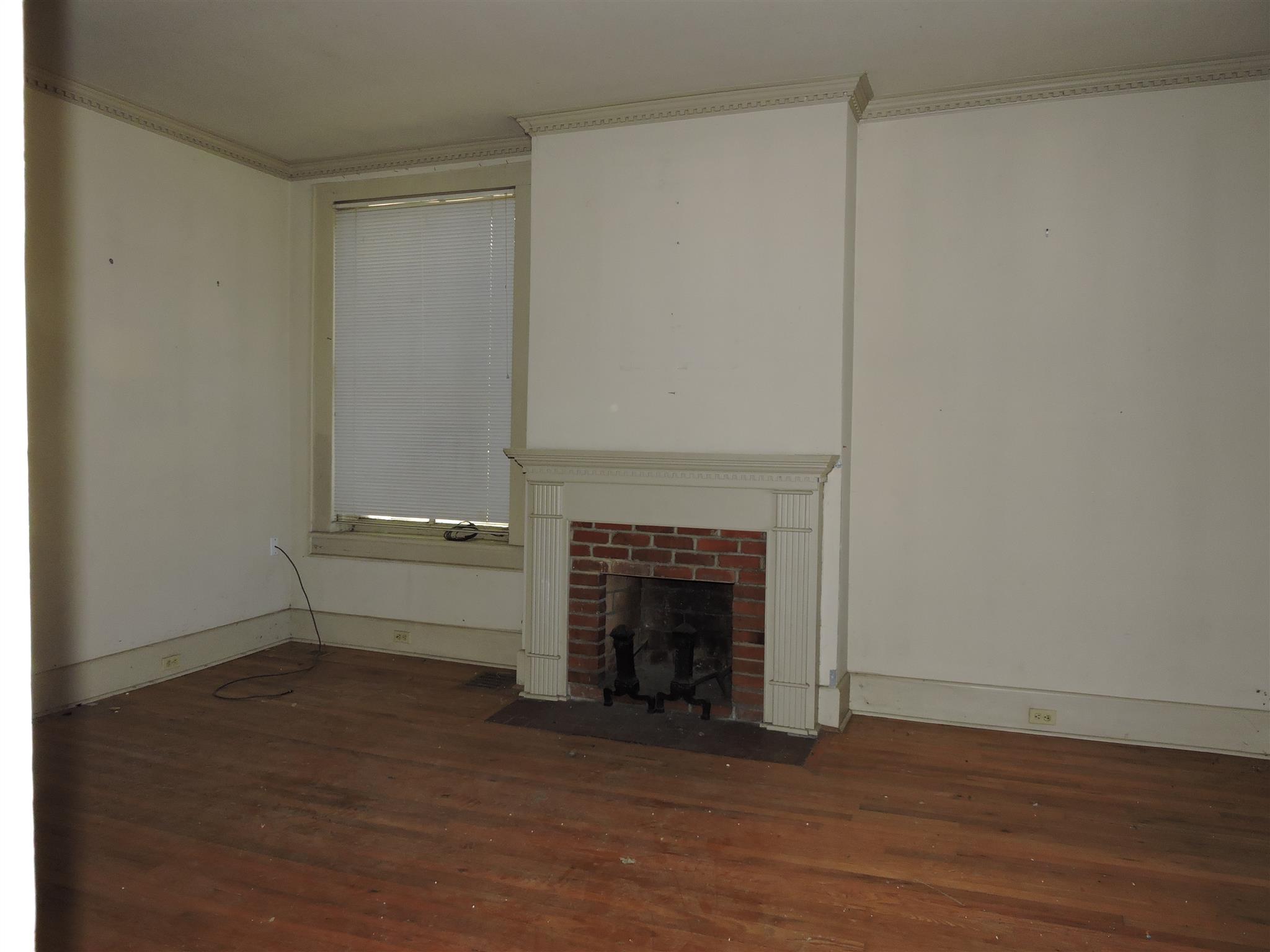 210 South High Street Winchester, TN 37398 - Photo 4 of 7 a view of empty room with wooden floor and fireplace