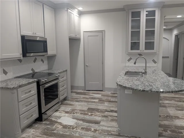 a kitchen with granite countertop a stove and a sink