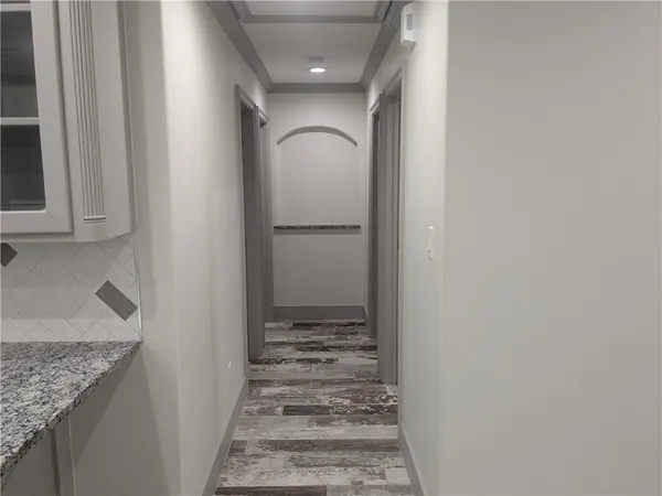 a view of a hallway with wooden floor and staircase