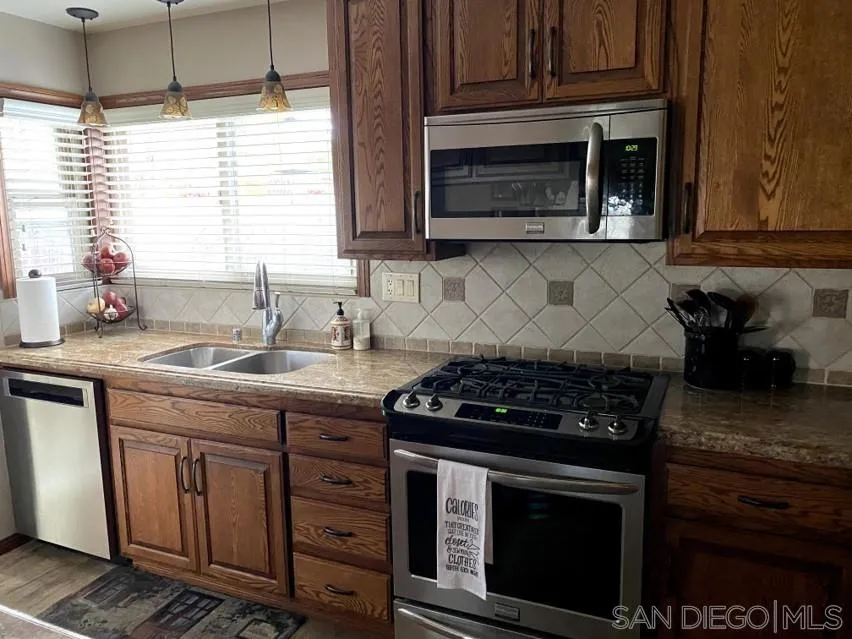 10835 Singletree Lane Spring Valley, CA 91978 - Photo 25 of 31 a kitchen with granite countertop a stove and a sink