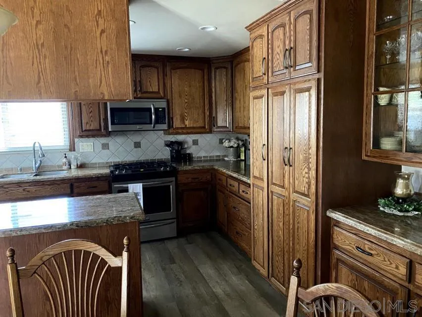 10835 Singletree Lane Spring Valley, CA 91978 - Photo 26 of 31 a kitchen with stainless steel appliances granite countertop a stove refrigerator sink and cabinets