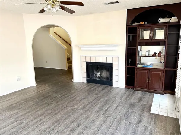 a living room with wooden floors and fireplace