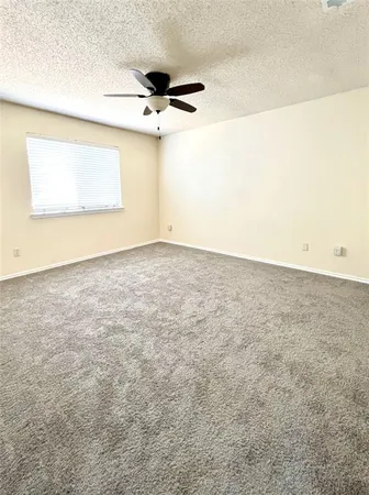 an empty room with a ceiling fan and a window