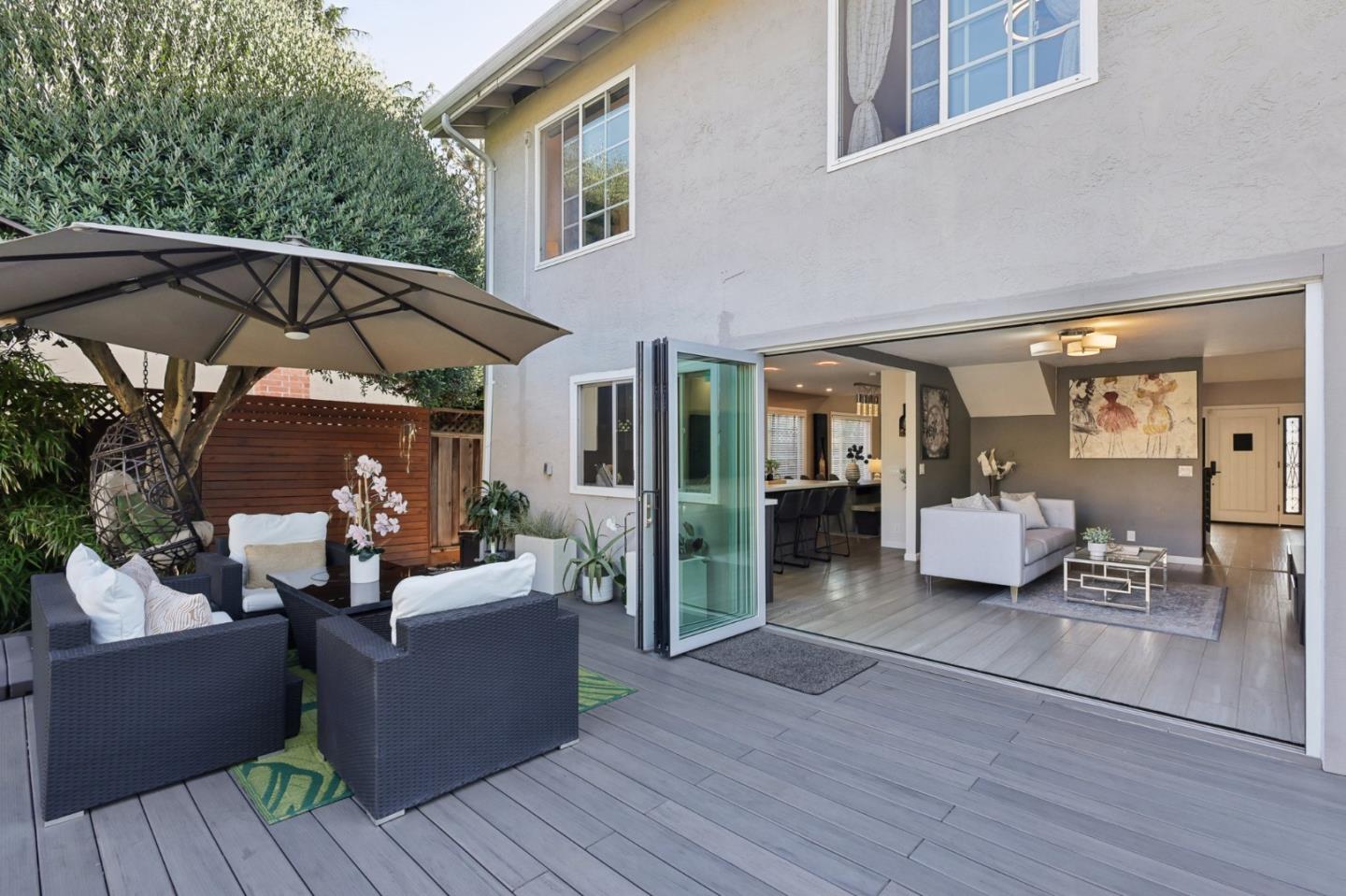 a view of a patio with couches table and chairs under an umbrella