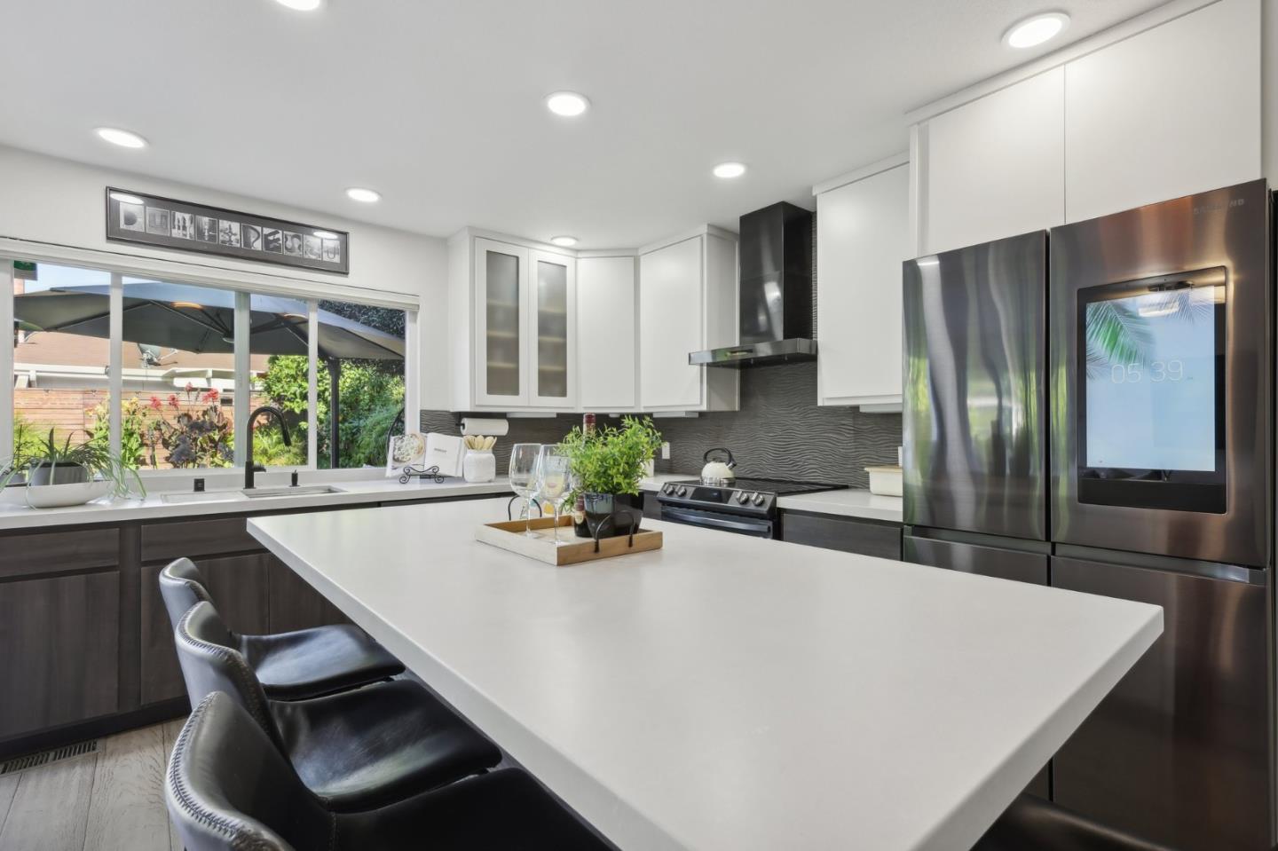 201 Prague Drive San Jose, CA 95119 - Photo 25 of 77 a kitchen with stainless steel appliances granite countertop a sink a stove a refrigerator a washer dryer and white cabinets