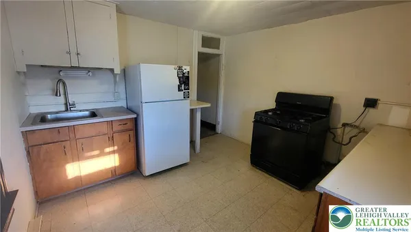 a kitchen with a refrigerator and a stove top oven