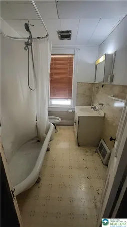 a bathroom with a tub sink shower and mirror
