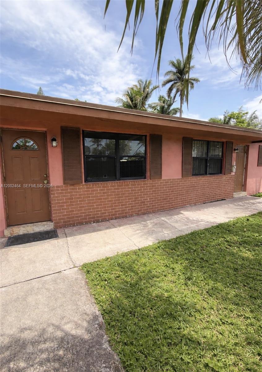 185 Northwest 82nd Street, Unit 1 Miami, FL 33150 - Photo 13 of 13 a front view of a house with a yard and garage