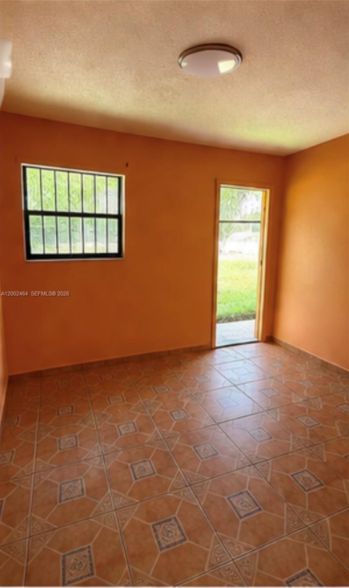 185 Northwest 82nd Street, Unit 1 Miami, FL 33150 - Photo 4 of 13 an empty room with windows