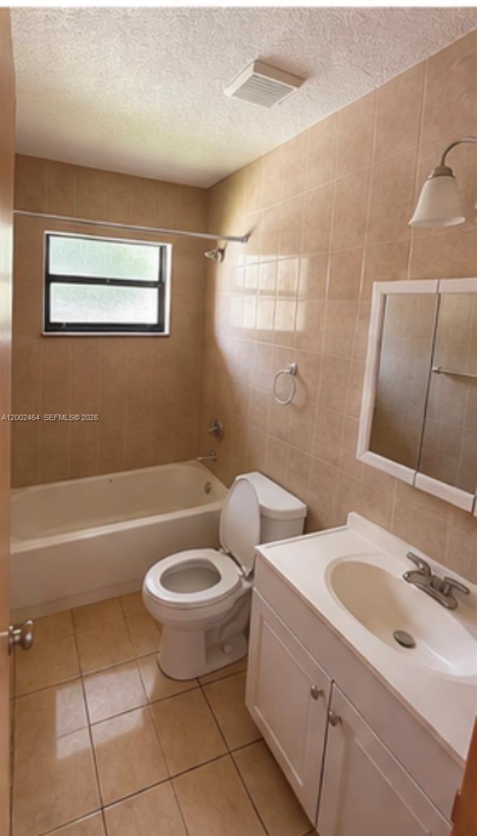 185 Northwest 82nd Street, Unit 1 Miami, FL 33150 - Photo 9 of 13 a bathroom with a toilet a sink a mirror and bathtub