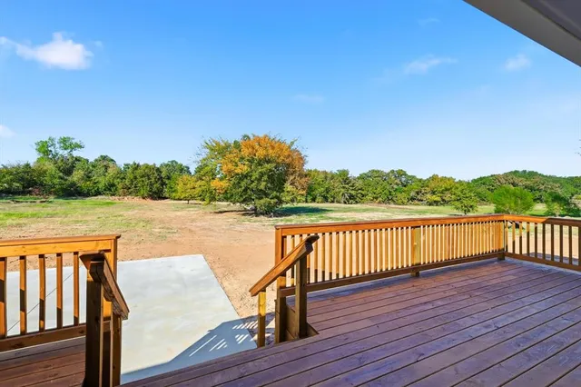a balcony with wooden floor and lake view