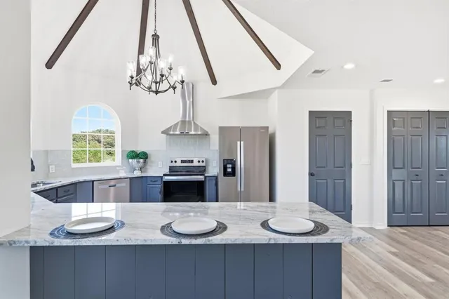 a kitchen with stainless steel appliances granite countertop a sink and a refrigerator
