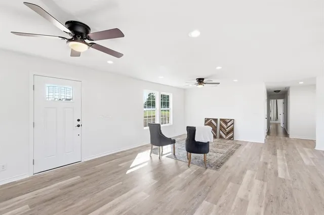 a living room with furniture and a ceiling fan