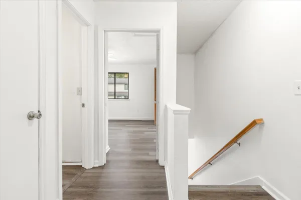 a view of a hallway with wooden floor and staircase