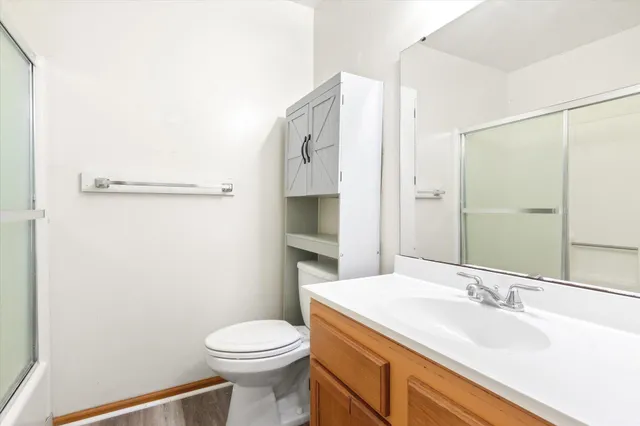 a bathroom with a sink a toilet and shower