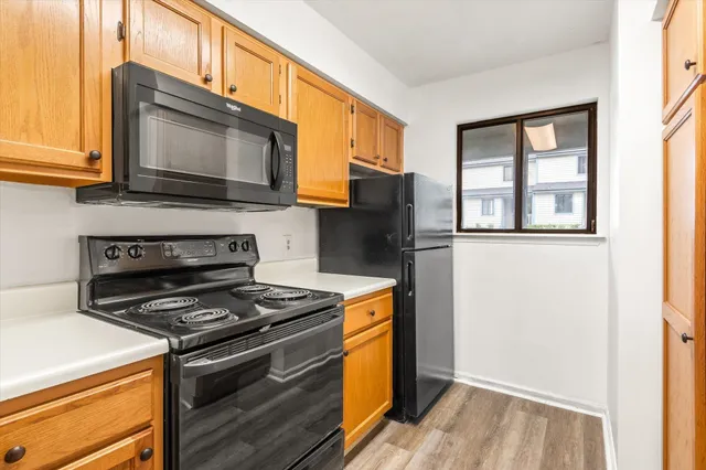 a kitchen with stainless steel appliances a stove a microwave and a window
