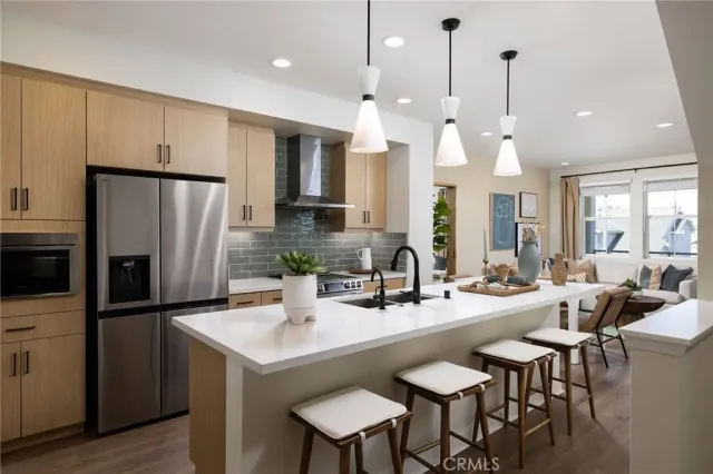 a kitchen with a refrigerator a sink dishwasher a dining table and chairs