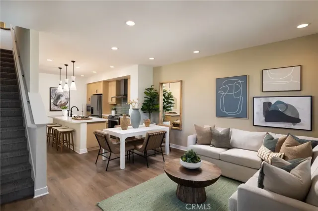 a living room with furniture a rug and kitchen view