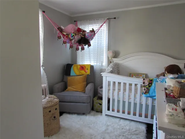 a living room with furniture and a baby crib
