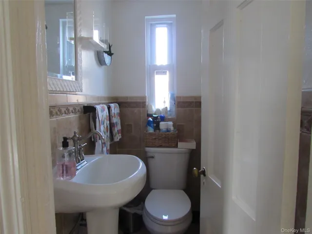 a bathroom with a sink a toilet a mirror and shower