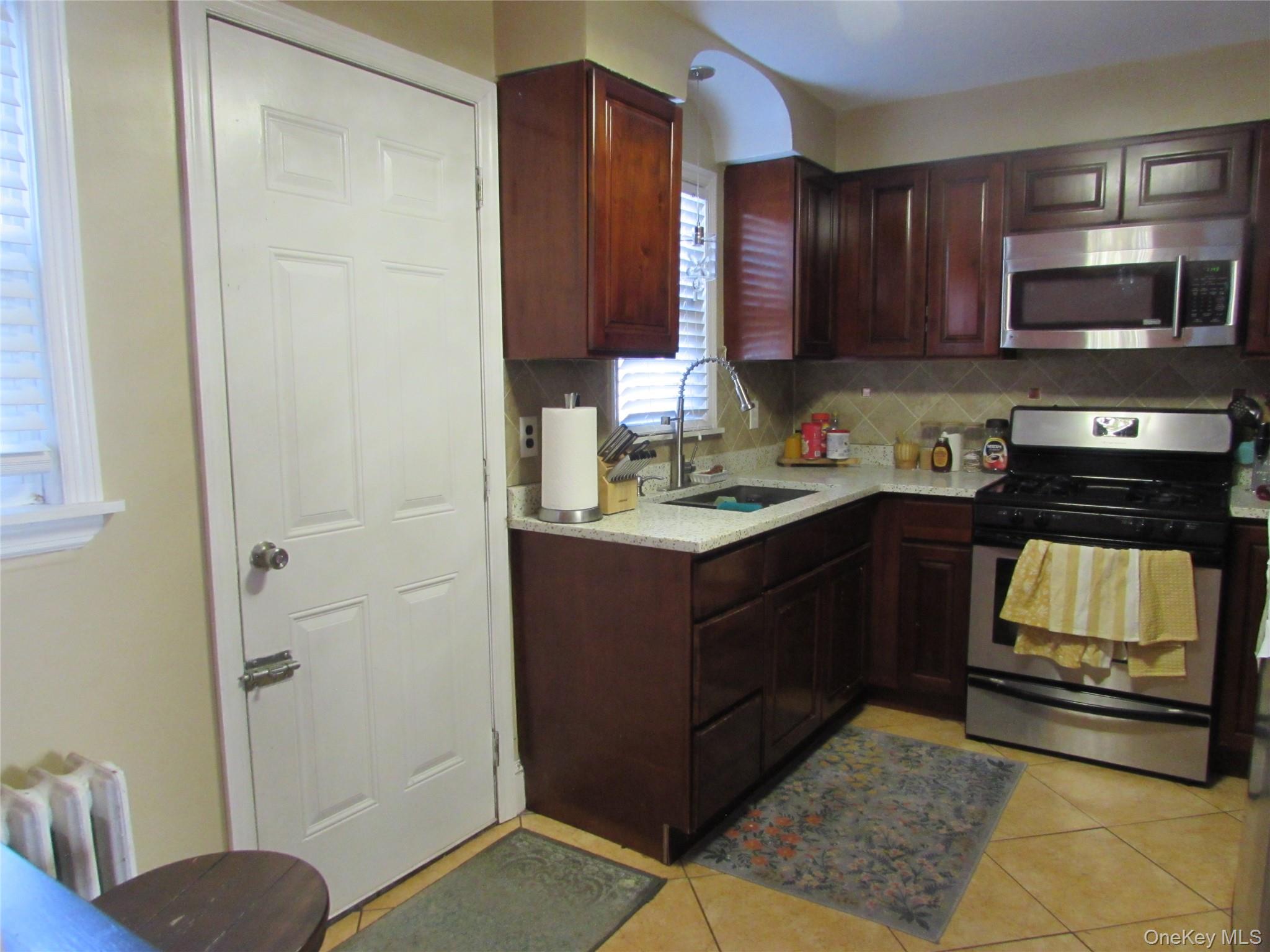 51 Phoenix Street Hempstead, NY 11550 - Photo 3 of 16 a kitchen with a refrigerator and a stove top oven