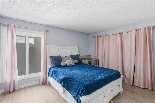 a large bed sitting in a bedroom next to a window