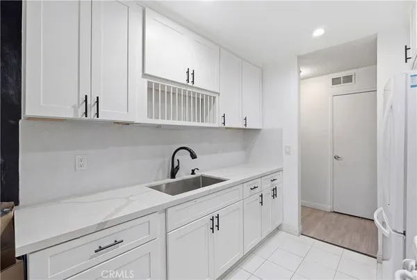 a kitchen with white cabinets and a sink