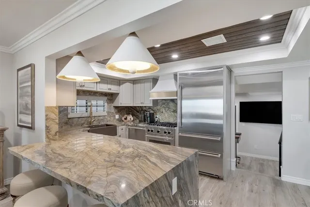 a kitchen with stainless steel appliances granite countertop a sink a stove and a wooden floors