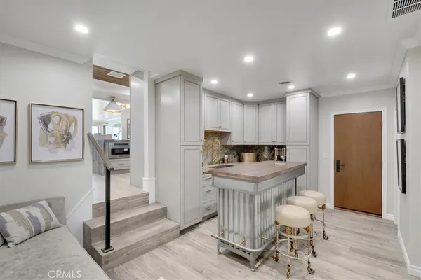 a kitchen with stainless steel appliances granite countertop a refrigerator a stove a sink dishwasher and a dining table with wooden floor