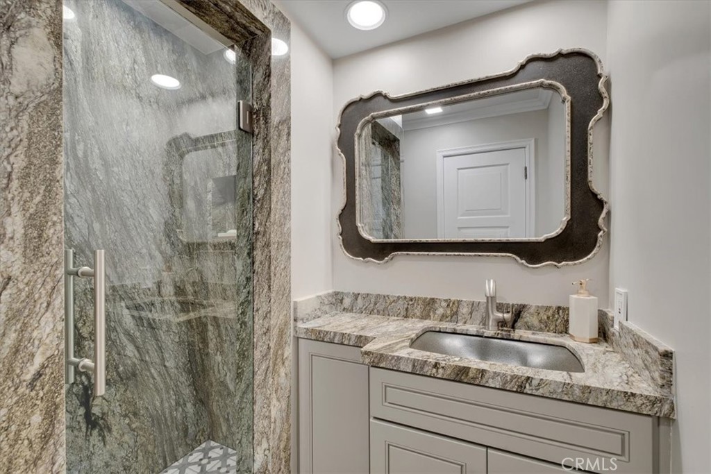 2808 West Oceanfront Newport Beach, CA 92663 - Photo 19 of 31 a bathroom with a granite countertop sink a mirror and shower