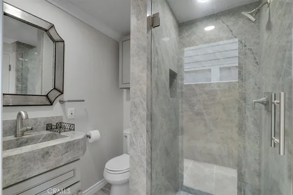 a bathroom with a sink a toilet and shower