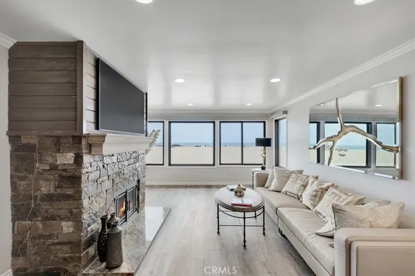 a living room with furniture a flat screen tv and a floor to ceiling window