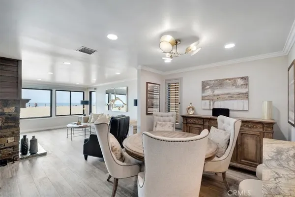 a very nice looking dining room with kitchen island furniture a large window and a chandelier