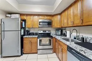 a kitchen with stainless steel appliances granite countertop a refrigerator a stove top oven a sink and dishwasher