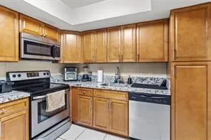 a kitchen with stainless steel appliances granite countertop a stove a sink and a microwave