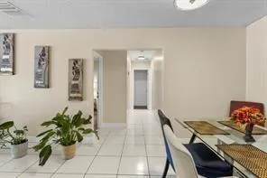 a dining room with furniture and a potted plant