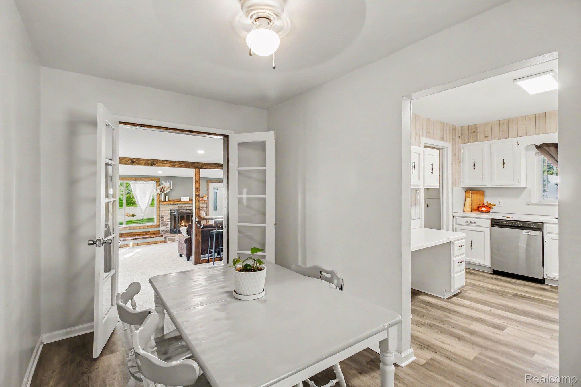 207 Elms Road Flushing, MI 48433 - Photo 7 of 30 White painted walls and trim, wood-finish flooring, and a ceiling fan