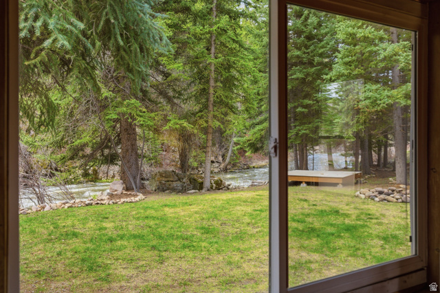 6631 Pine Springs Road Kamas, UT 84036 - Photo 41 of 48 View of green lawn with a water view, a sunroom, and view of wooded area