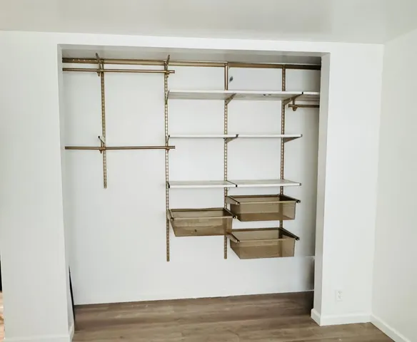 a view of walk in closet with empty racks