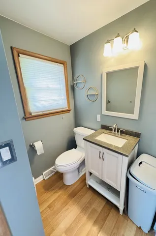 a bathroom with a granite countertop toilet a sink and a mirror