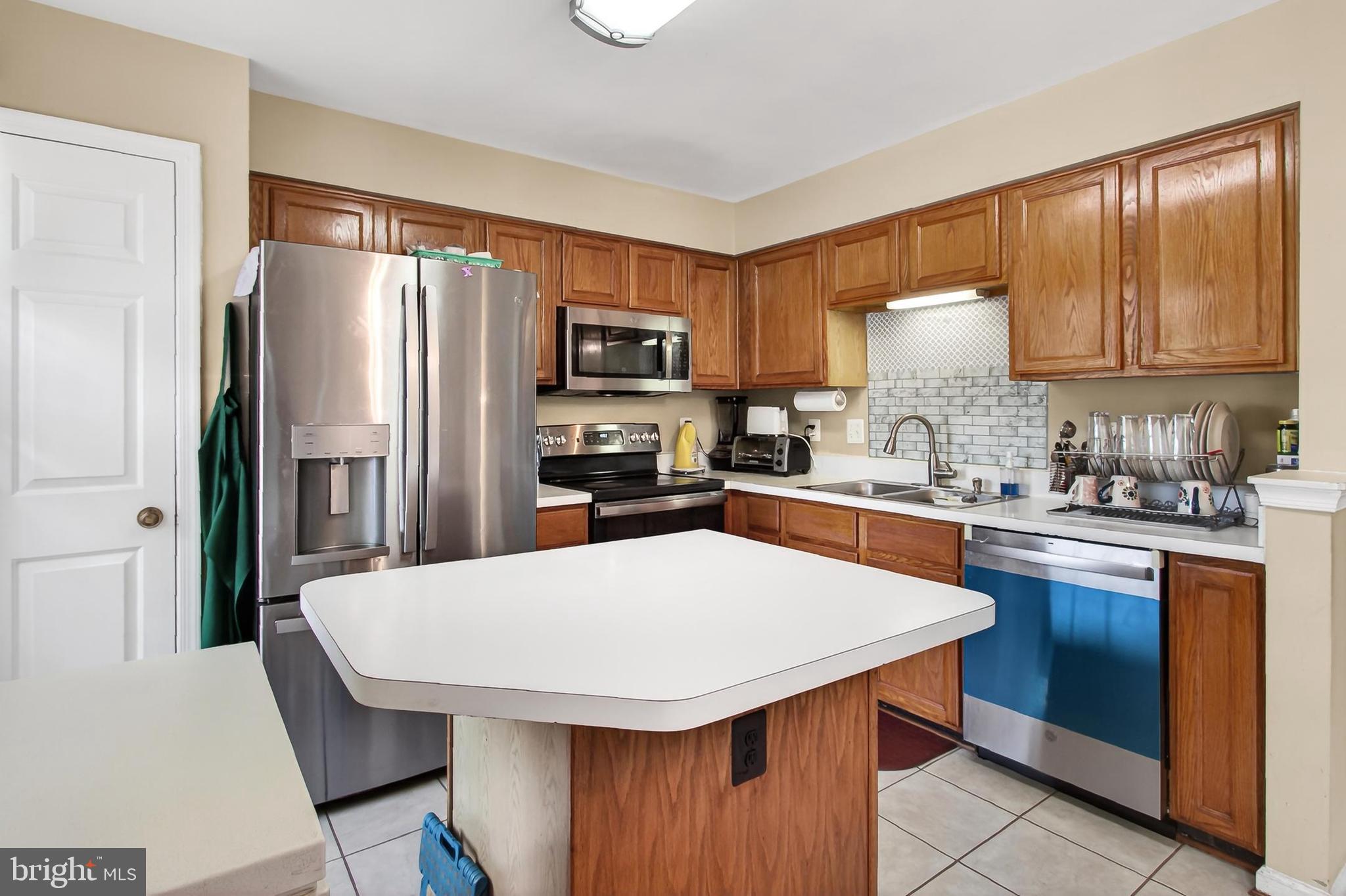 8602 Walcott Court Manassas, VA 20111 - Photo 14 of 53 a kitchen with stainless steel appliances a refrigerator stove microwave and sink