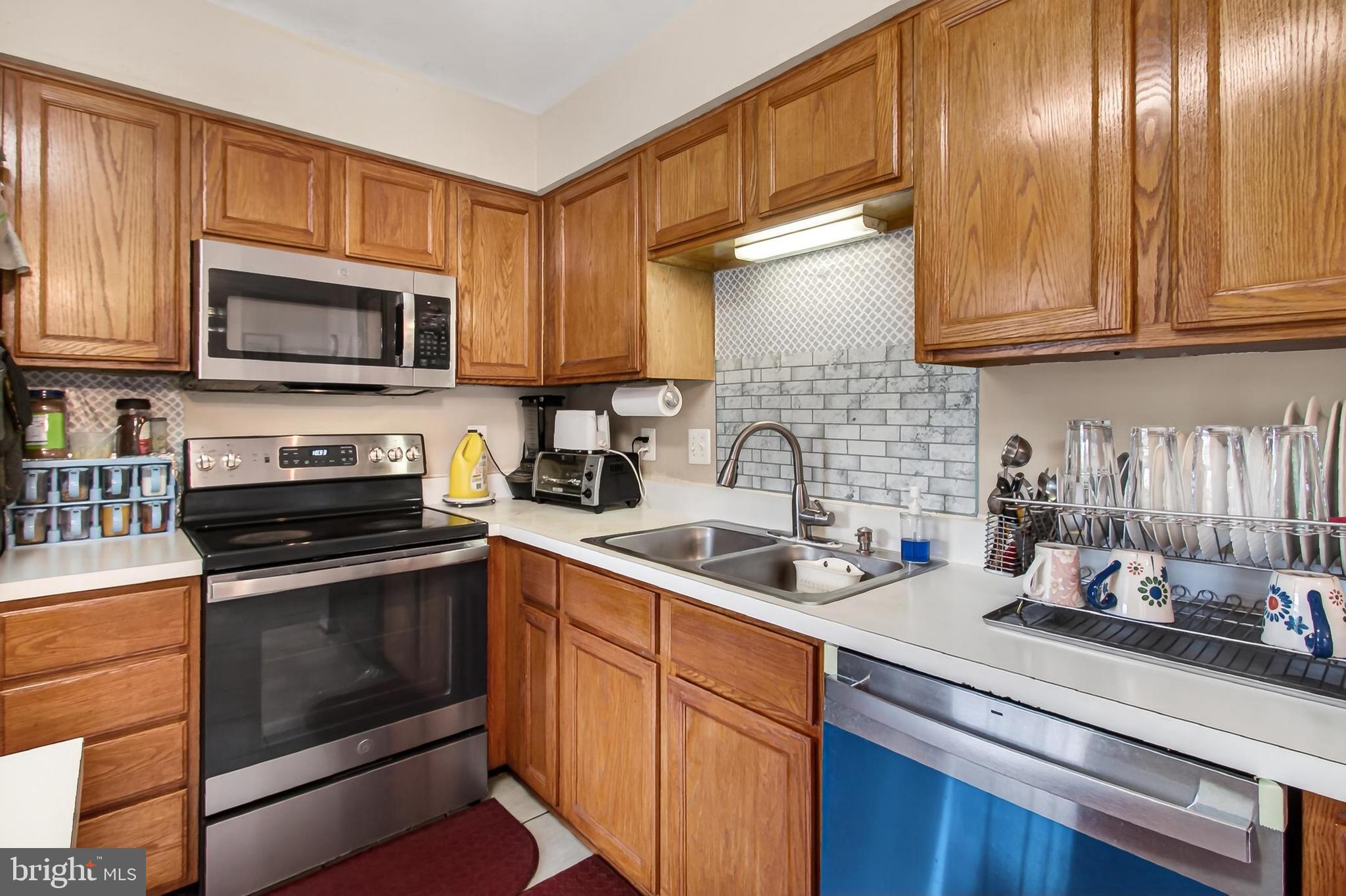 8602 Walcott Court Manassas, VA 20111 - Photo 17 of 53 a kitchen with stainless steel appliances granite countertop a sink stove and microwave