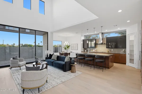 a living room with furniture kitchen view and a large window