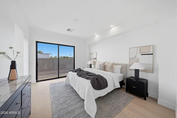 a spacious bedroom with a bed and a large mirror